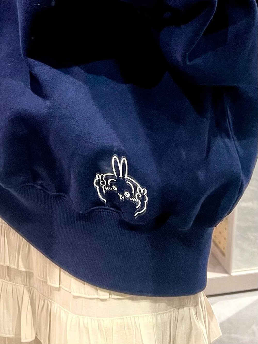 ブラック系のサンダル、ホワイト系のスカート、ブルー系のスウェットを着用したレディースの冬コーディネートの3枚目の写真