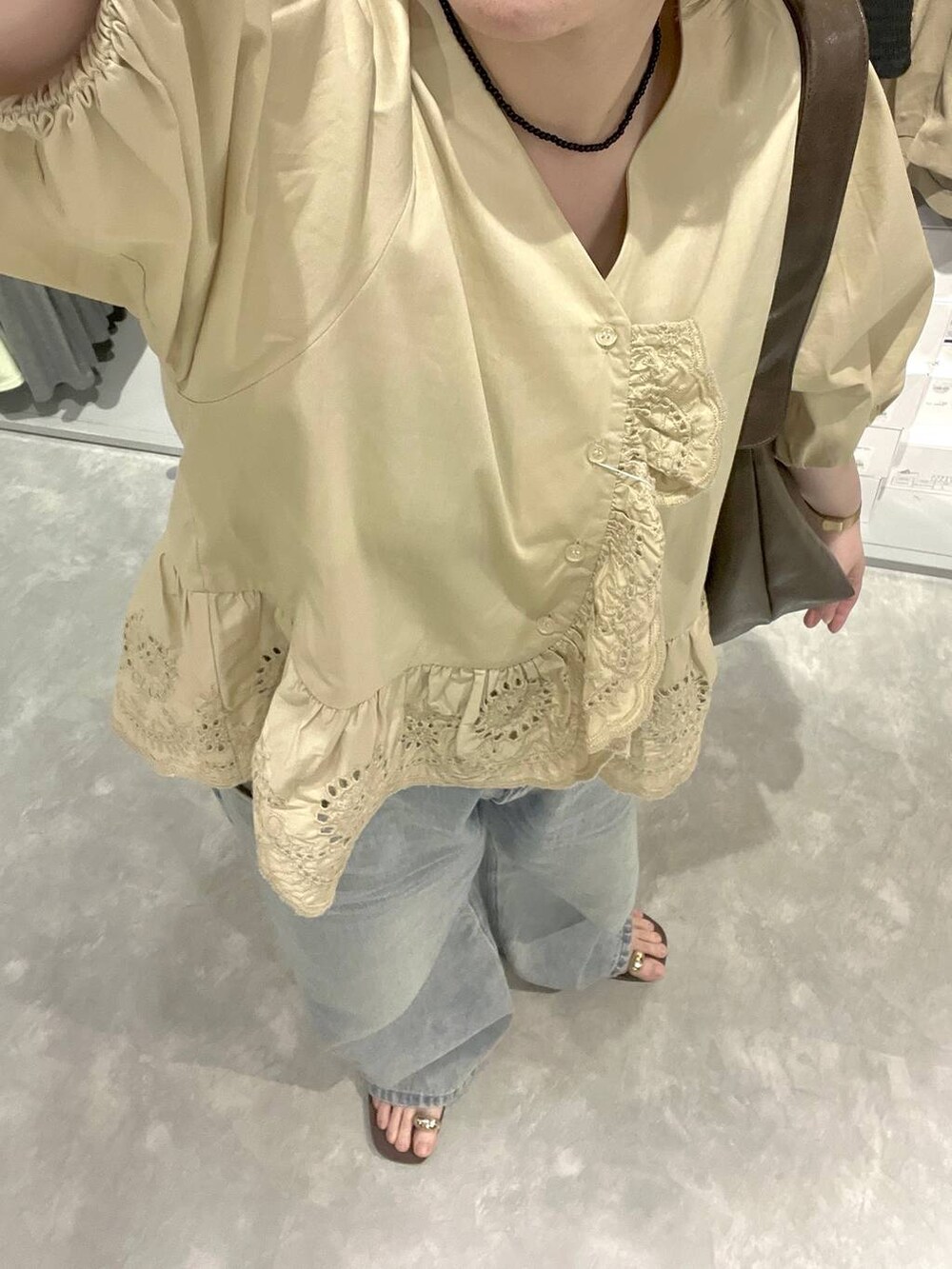 ブルー系のデニムパンツ、ブラウン系のサンダル、ベージュ系のシャツ/ブラウスを着用したレディースの春コーディネートの7枚目の写真