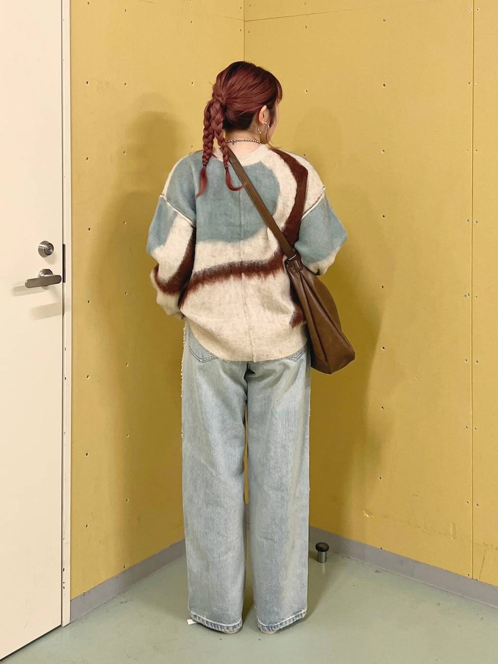 シルバー系のパンプス、ホワイト系のニット/セーター、ブラウン系のショルダーバッグを着用したレディースの秋コーディネートの2枚目の写真