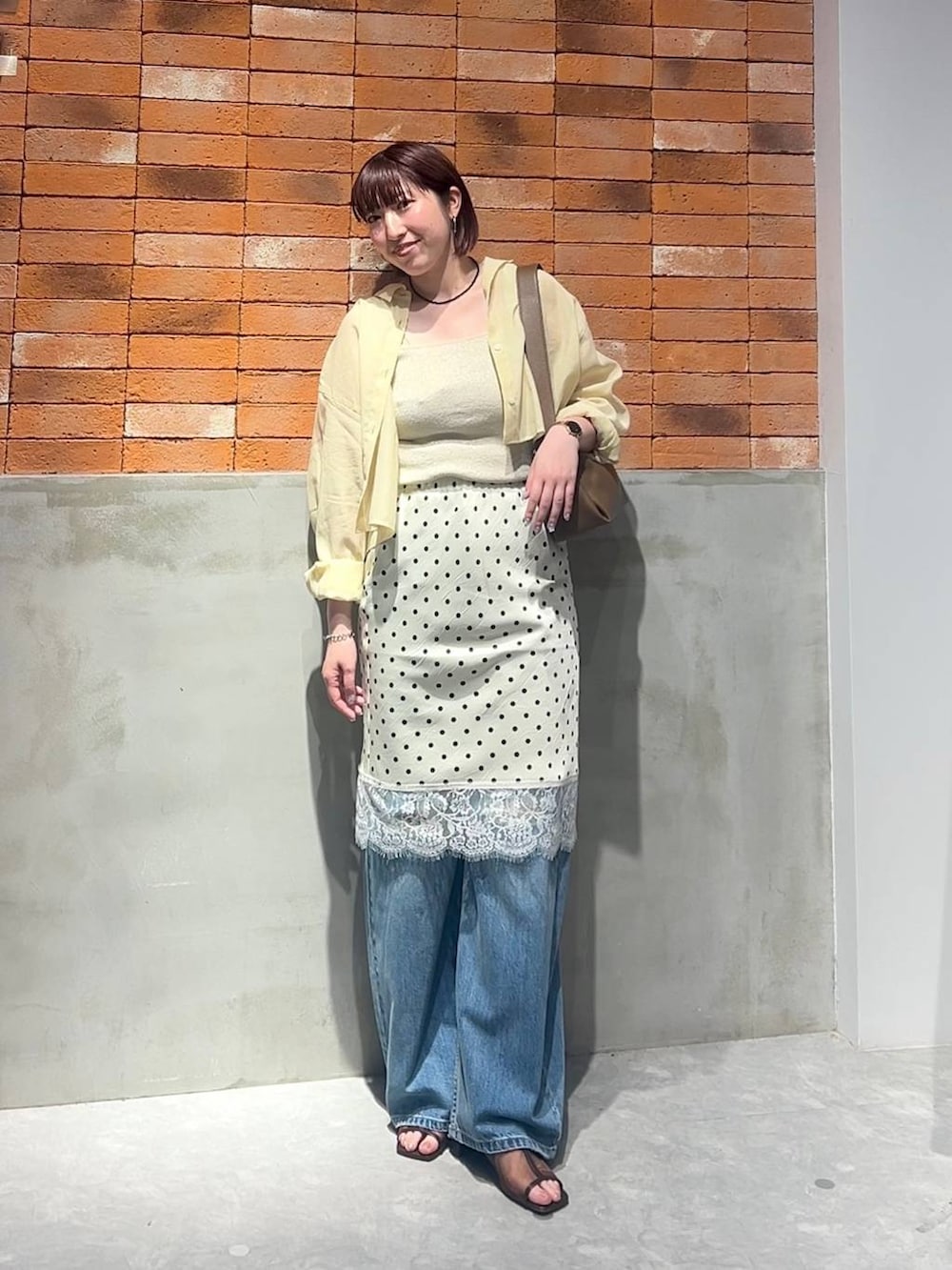 ゴールド系のタンクトップ、イエロー系のシャツ/ブラウス、ブルー系のデニムパンツを着用したレディースの夏コーディネートの6枚目の写真