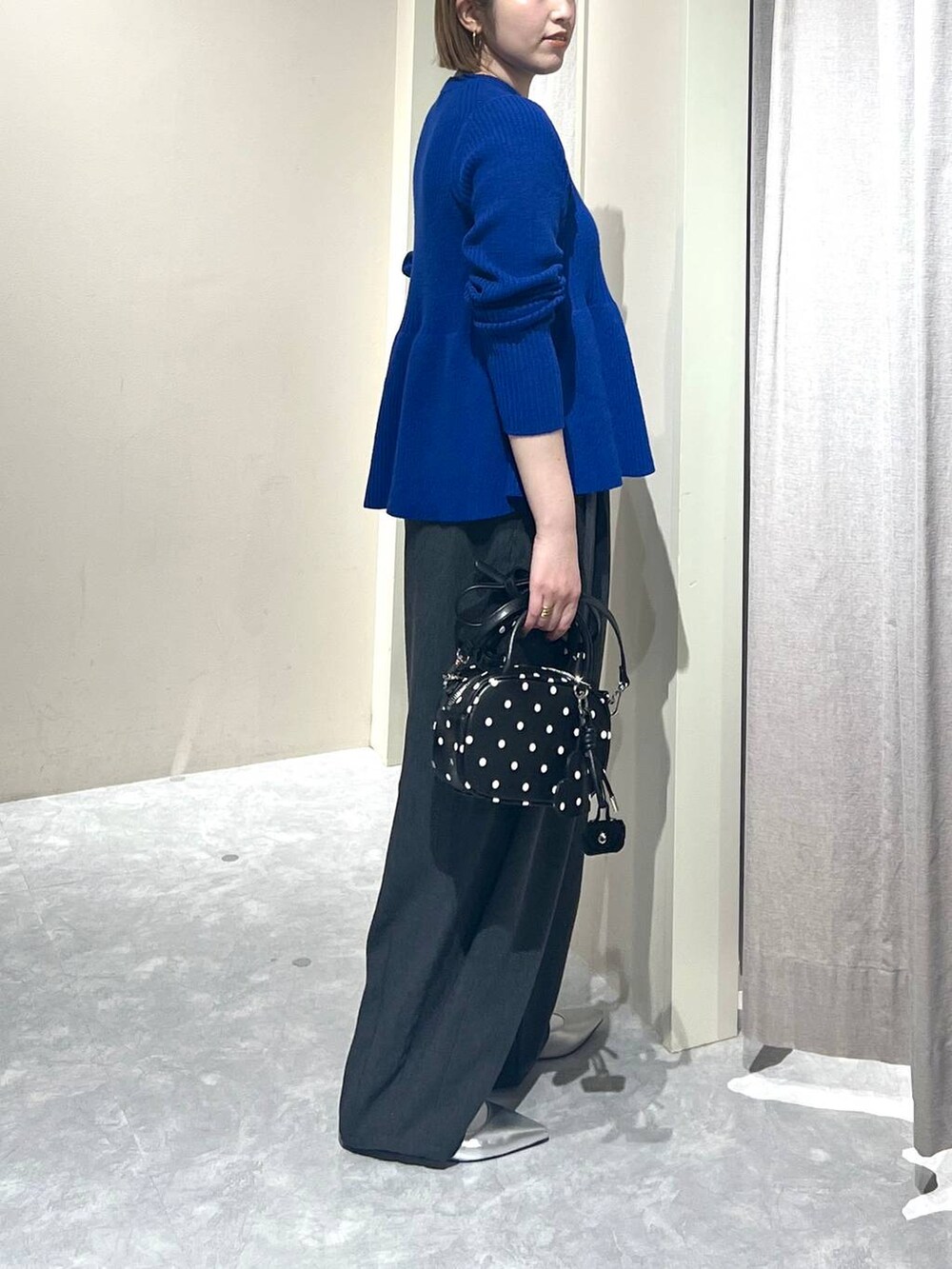 グレー系のその他パンツ、シルバー系のパンプス、その他のボストンバッグを着用したレディースの秋コーディネートの2枚目の写真