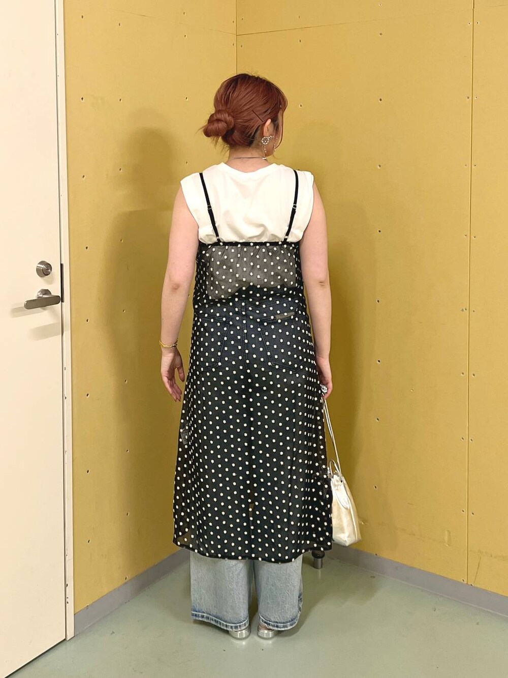 シルバー系のパンプス、シルバー系のショルダーバッグ、ブルー系のデニムパンツを着用したレディースの夏コーディネートの3枚目の写真