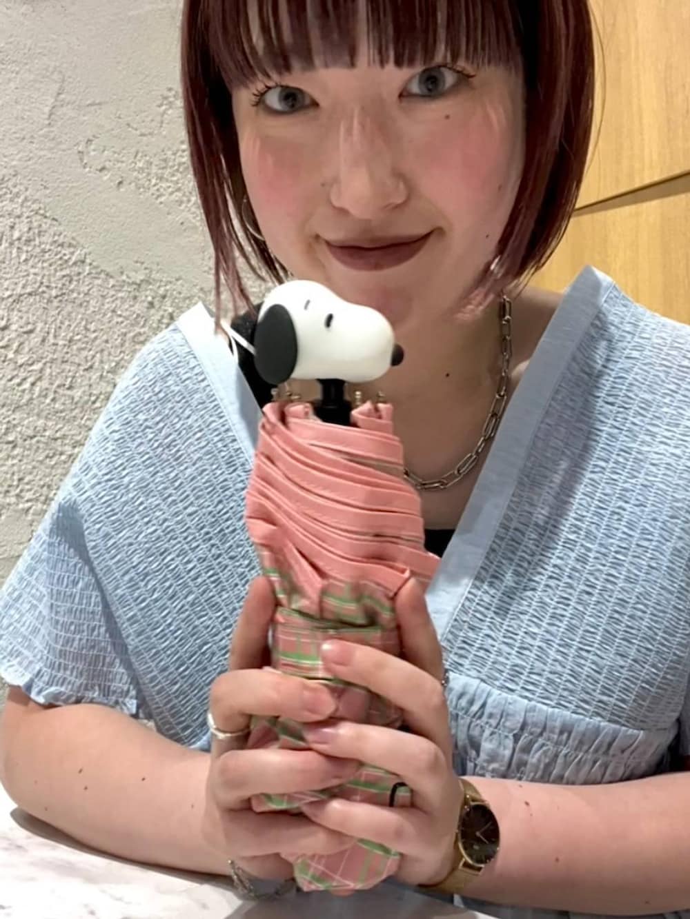 ブラック系のタンクトップ、ブルー系のシャツ/ブラウス、ピンク系の折りたたみ傘を着用したレディースの夏コーディネートの3枚目の写真