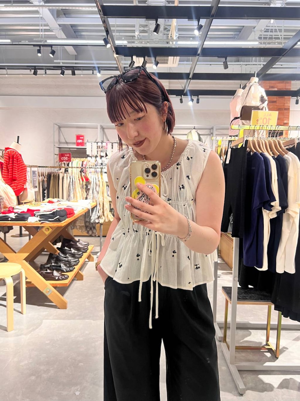ブラック系のデニムパンツ、ブラック系のサンダル、ホワイト系のシャツ/ブラウスを着用したレディースの夏コーディネートの4枚目の写真