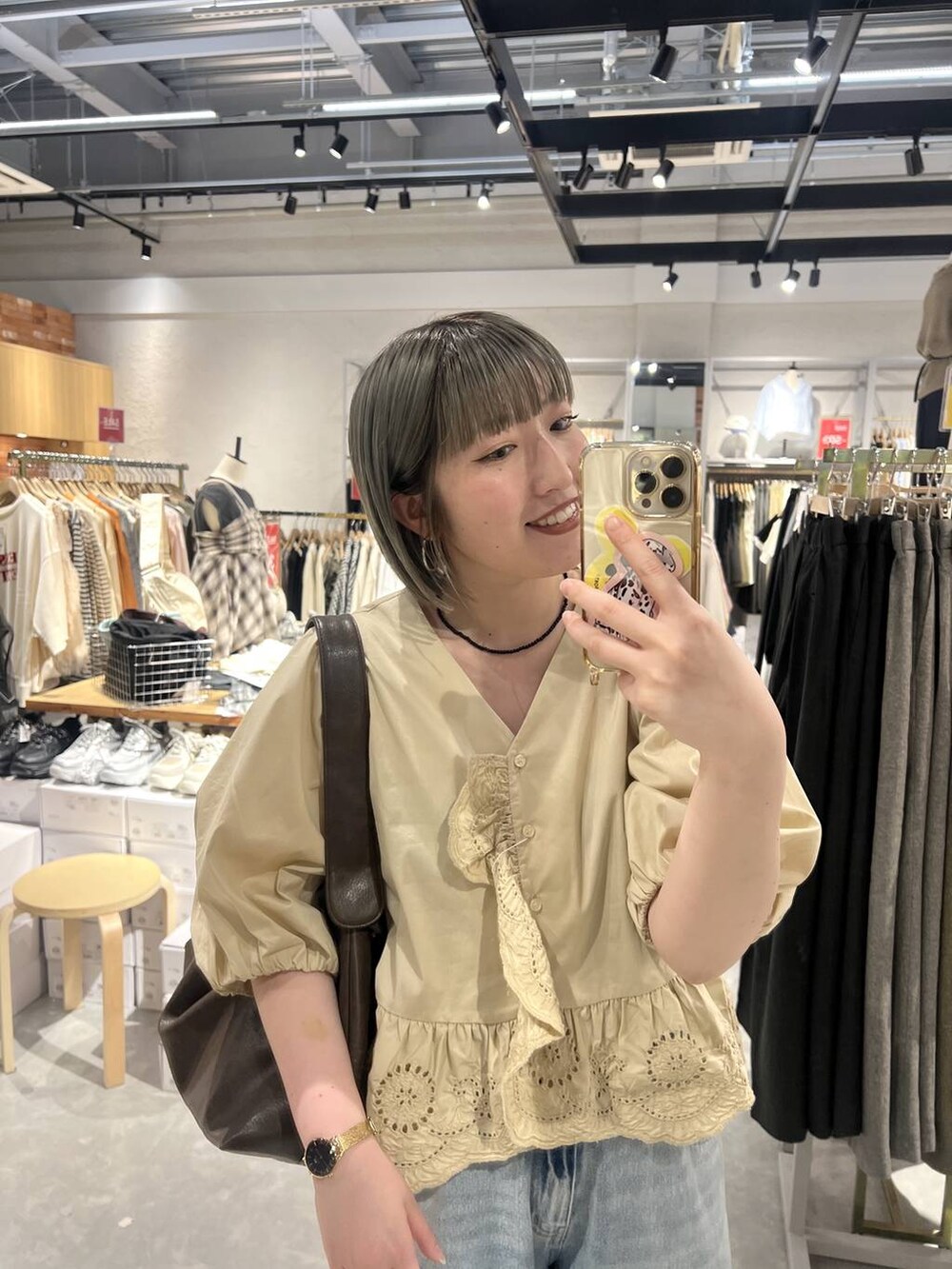 ブルー系のデニムパンツ、ブラウン系のサンダル、ベージュ系のシャツ/ブラウスを着用したレディースの春コーディネートの5枚目の写真