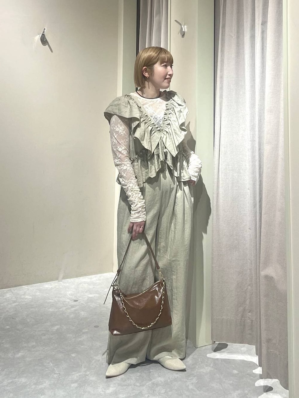 ブラウン系のショルダーバッグ、ホワイト系のパンプス、ホワイト系のTシャツ/カットソーを着用したレディースの春コーディネートの4枚目の写真