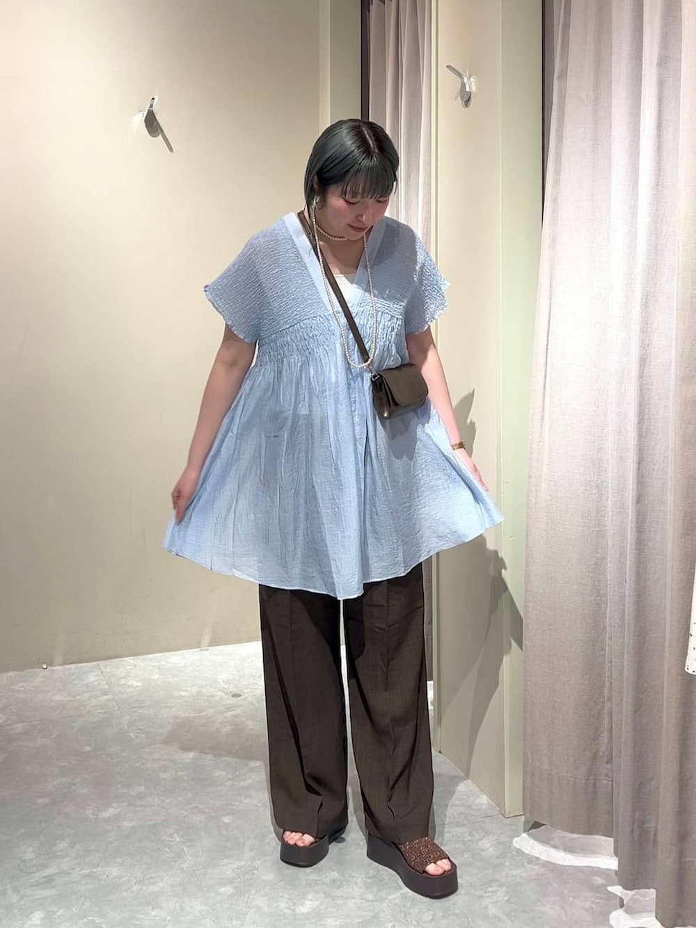 シルバー系のタンクトップ、ブルー系のシャツ/ブラウス、ブラウン系のスラックスを着用したレディースの春コーディネートの5枚目の写真
