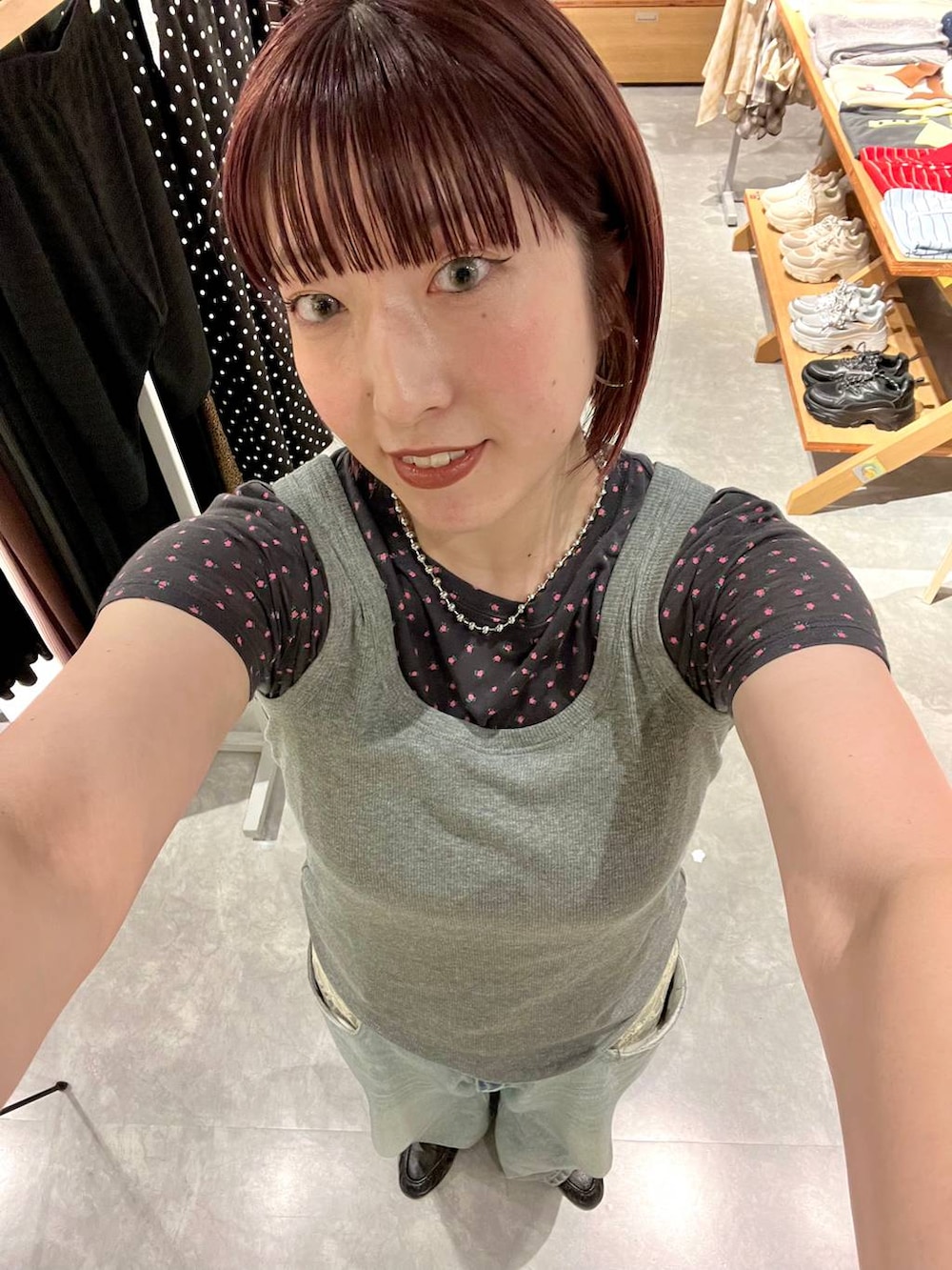グレー系のタンクトップ、ブルー系のデニムパンツ、ブラック系のローファーを着用したレディースの夏コーディネートの7枚目の写真