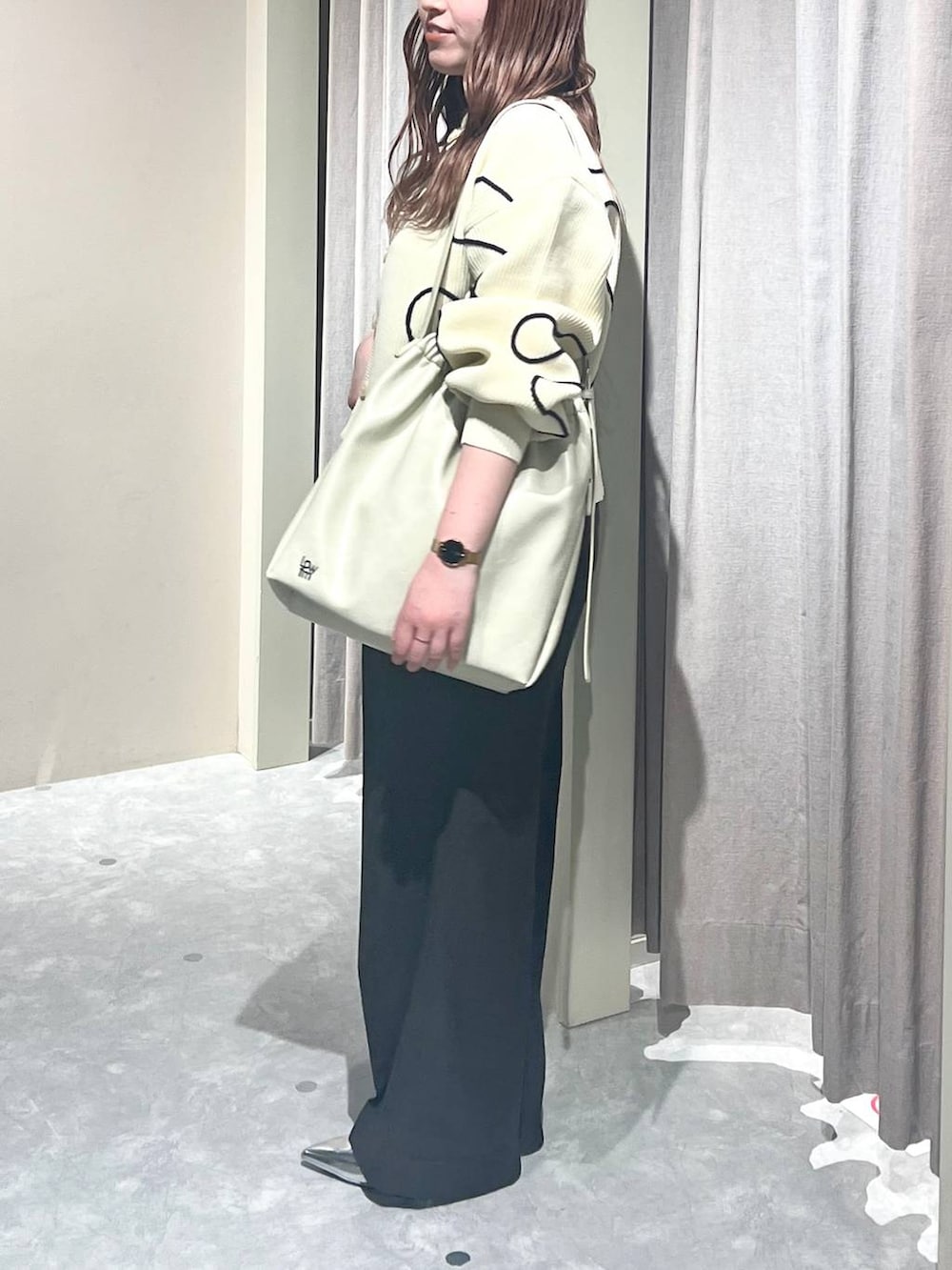 ホワイト系のショルダーバッグ、グレー系のスラックス、シルバー系のパンプスを着用したレディースの春コーディネートの2枚目の写真