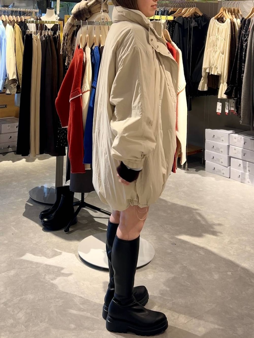 ホワイト系のブルゾン、グレー系のその他パンツ、ブラック系のブーツを着用したレディースの秋コーディネートの2枚目の写真