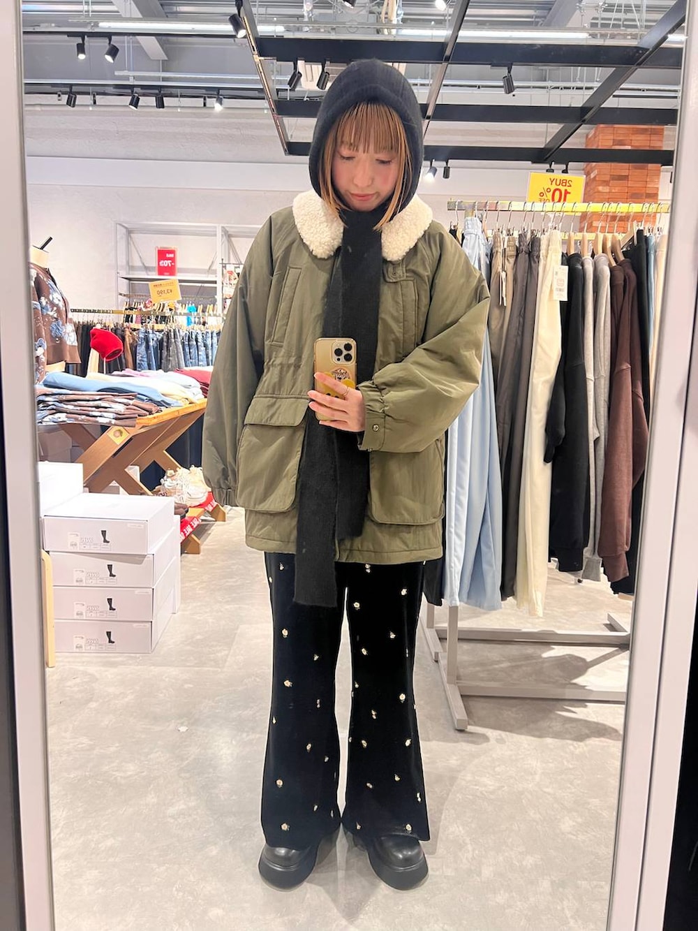 グリーン系のその他アウター、ブラック系のサンダル、ブルー系のその他パンツを着用したレディースの冬コーディネートの2枚目の写真