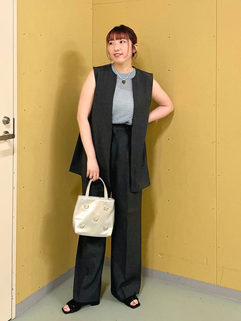 ブラック系のサンダル、シルバー系のショルダーバッグ、グレー系のベストを着用したレディースの夏コーディネートの4枚目の写真