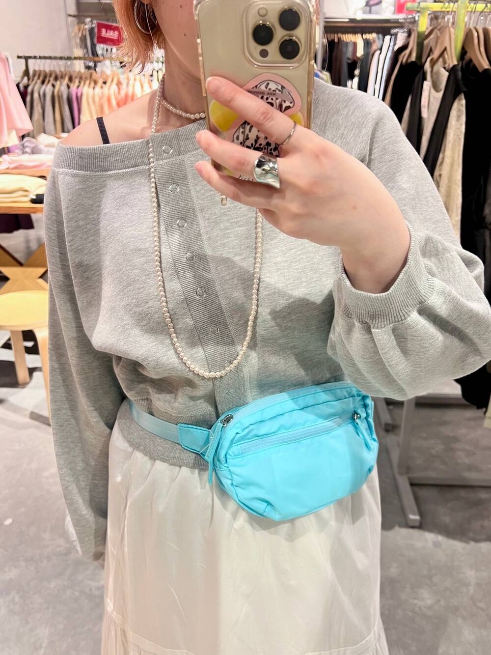 ブルー系のボディバッグ/ウエストポーチ、ブラック系のドレスシューズ、ホワイト系のスカートを着用したレディースの春コーディネートの5枚目の写真