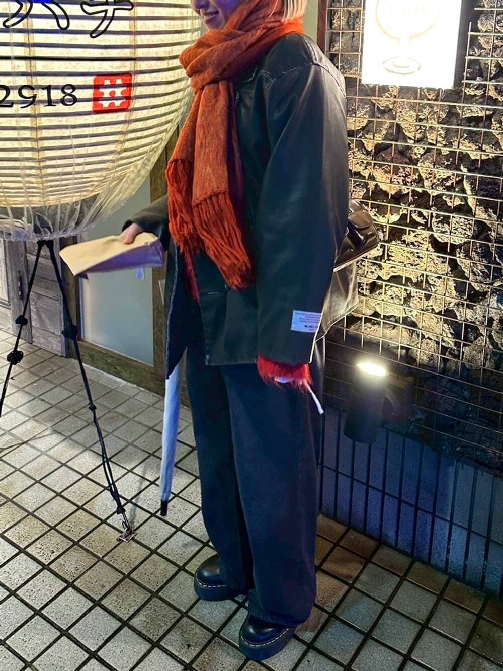 ブラック系のデニムパンツ、ブラック系のその他アウター、ホワイト系のシャツ/ブラウスを着用したレディースの冬コーディネートの4枚目の写真