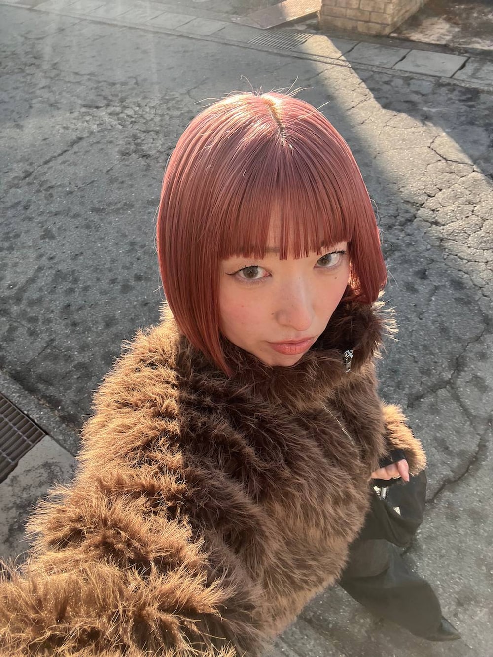 ブラウン系のブルゾン、ブラック系のデニムパンツ、ブラック系のパンプスを着用したレディースの冬コーディネートの5枚目の写真