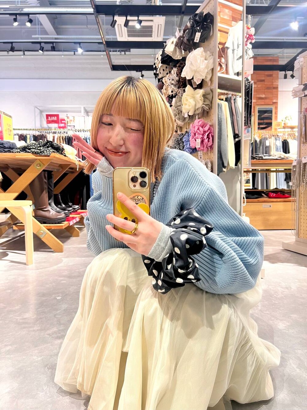 ブルー系のカーディガン/ボレロ、ブラック系のパンプス、ブルー系のデニムパンツを着用したレディースの冬コーディネートの3枚目の写真