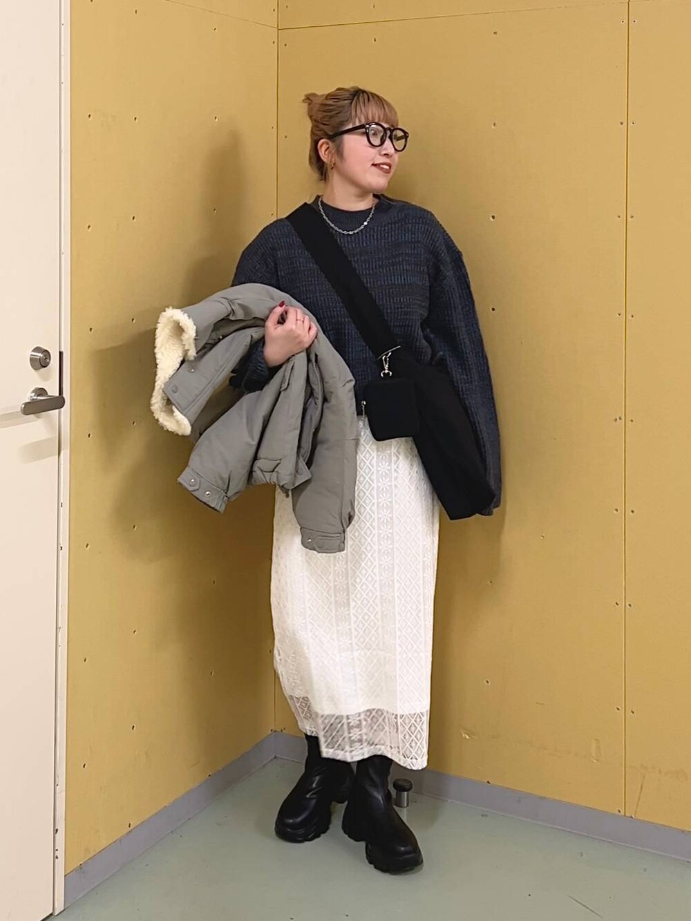 ブラック系のブーツ、ブルー系のワンピース、グリーン系のブルゾンを着用したレディースの冬コーディネートの5枚目の写真