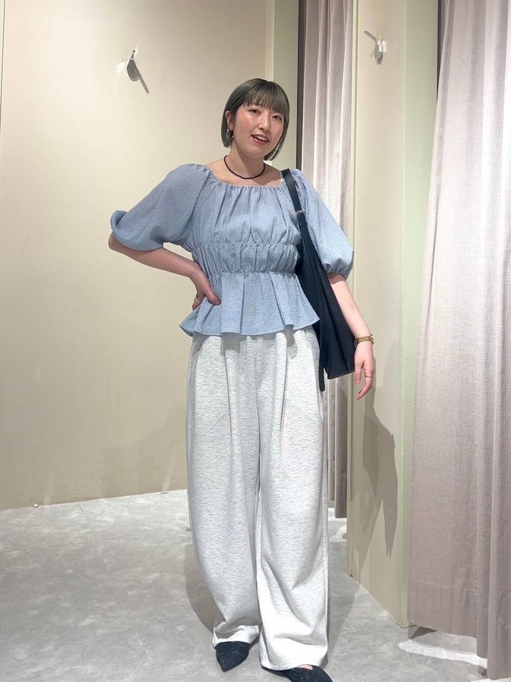 ブラック系のショルダーバッグ、グレー系のスウェットパンツ、ブラック系のパンプスを着用したレディースの春コーディネートの4枚目の写真