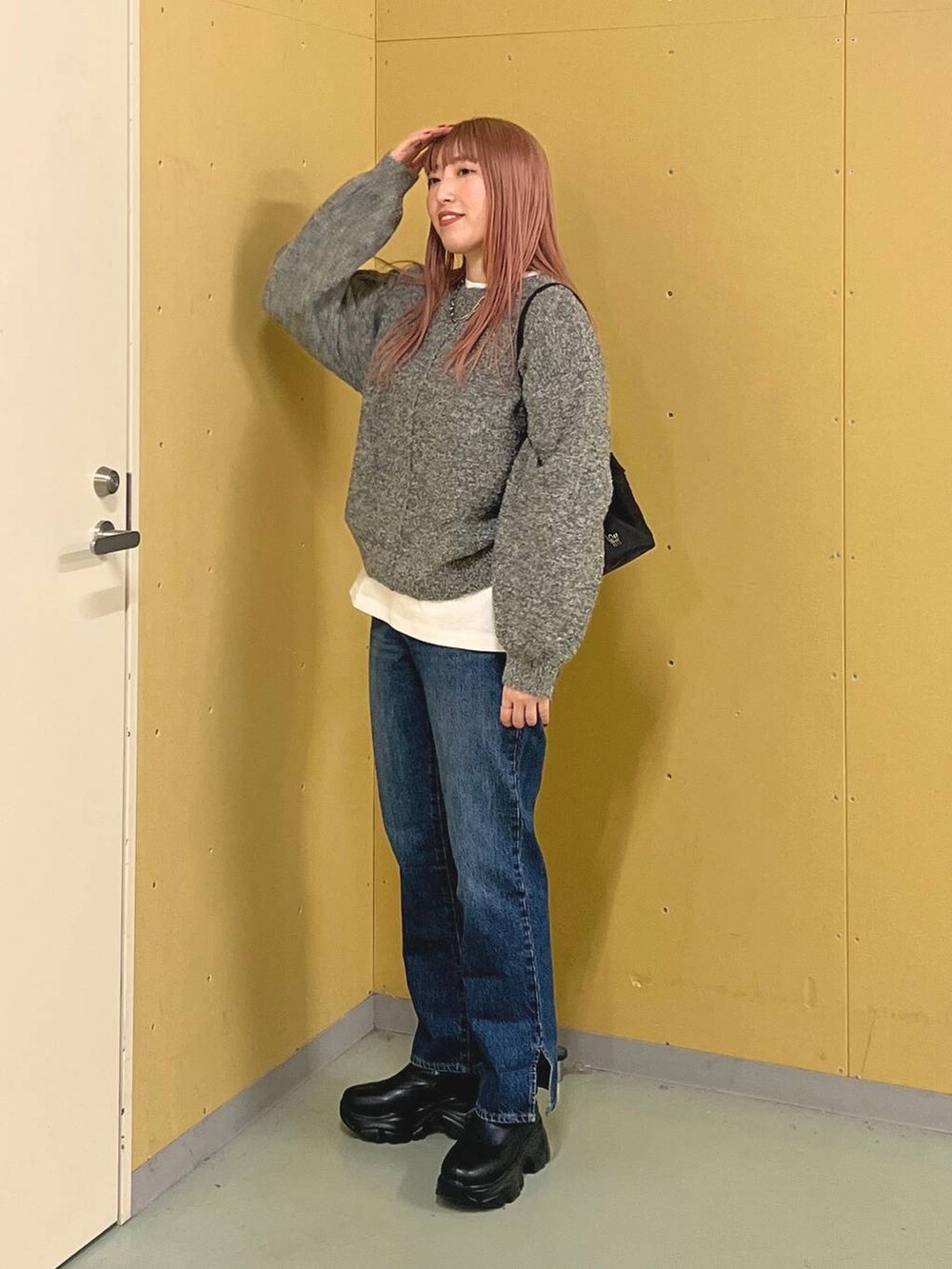ブルー系のデニムパンツ、ブラック系のブーツ、ホワイト系のTシャツ/カットソーを着用したレディースの冬コーディネートの2枚目の写真