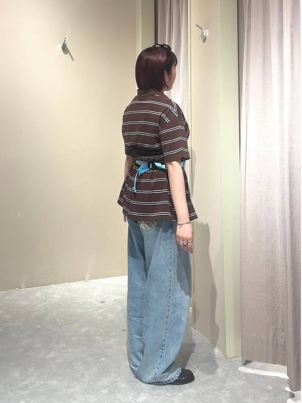 ブルー系のデニムパンツ、ブルー系のボディバッグ/ウエストポーチ、ブラウン系のローファーを着用したレディースの春コーディネートの2枚目の写真