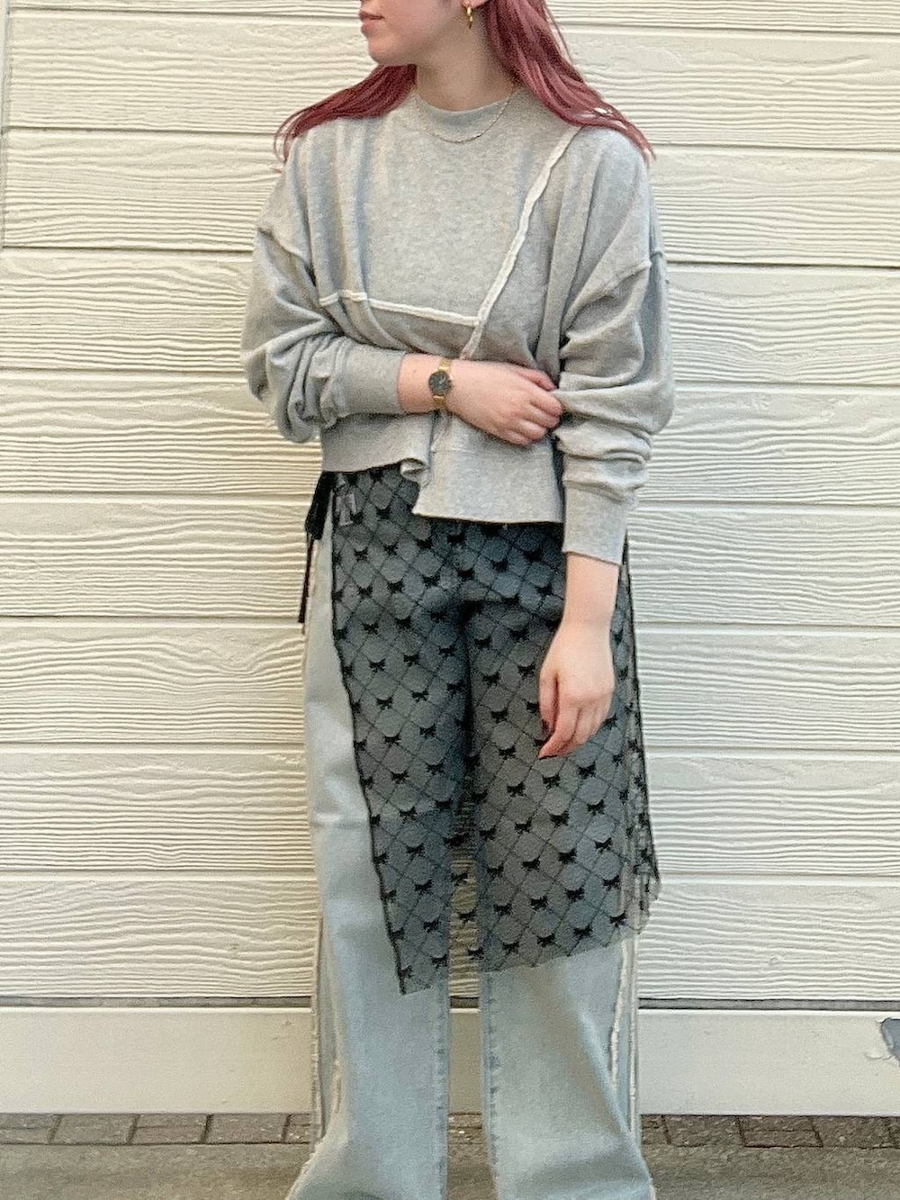 ブルー系のデニムパンツ、グレー系のスウェット、シルバー系のピアス(両耳用)を着用したレディースの秋コーディネートの2枚目の写真