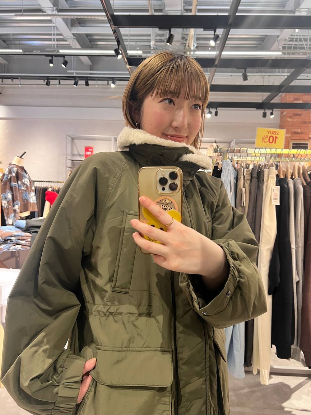 グリーン系のその他アウター、ブラック系のサンダル、ブルー系のその他パンツを着用したレディースの冬コーディネートの3枚目の写真