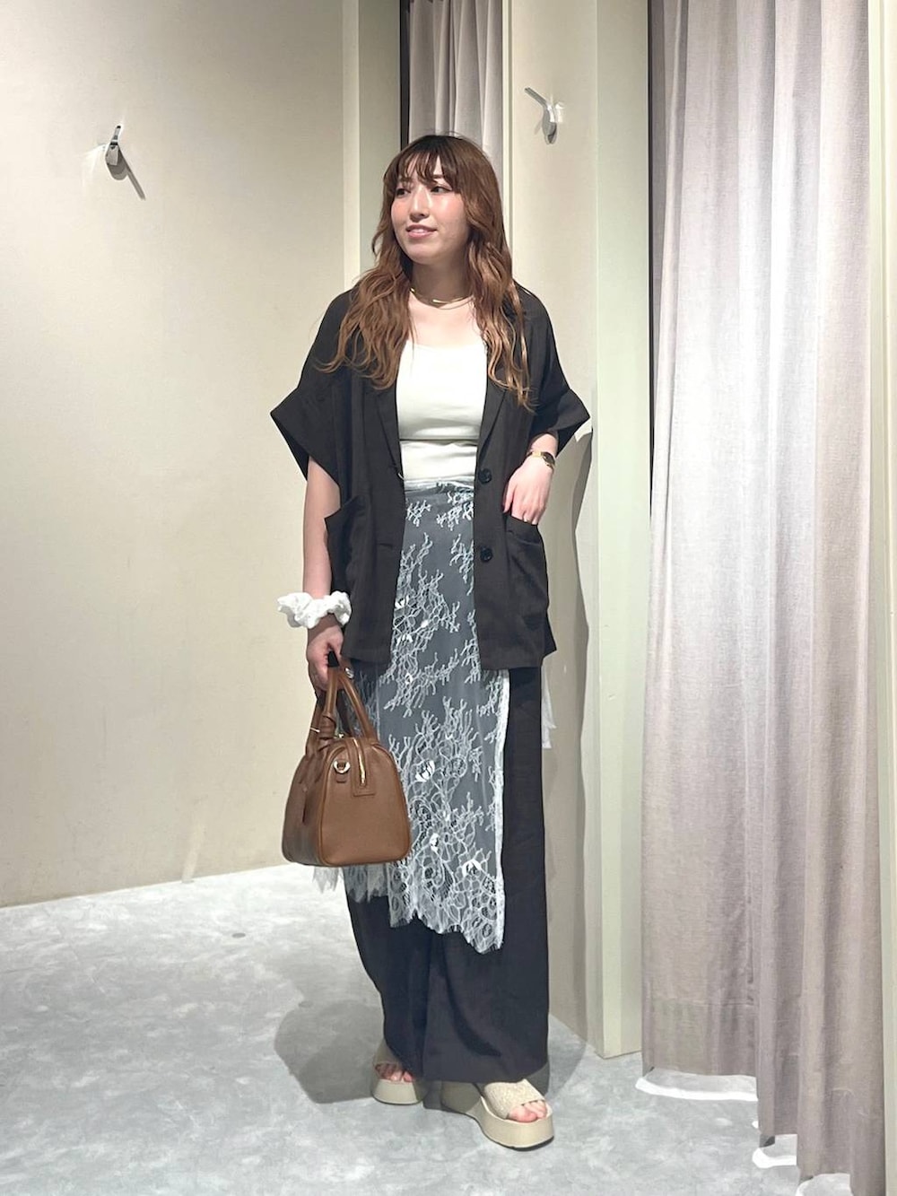 ホワイト系のTシャツ/カットソー、ホワイト系のサンダル、ブラウン系のテーラードジャケットを着用したレディースの秋コーディネートの5枚目の写真