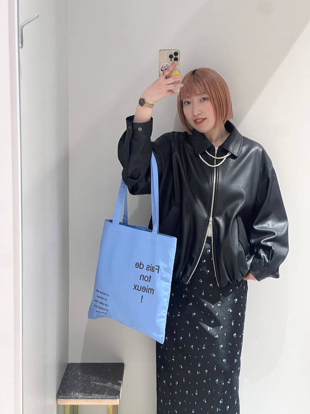 ブラック系のスカート、ブラック系のサンダル、ブルー系のトートバッグを着用したレディースの冬コーディネートの6枚目の写真