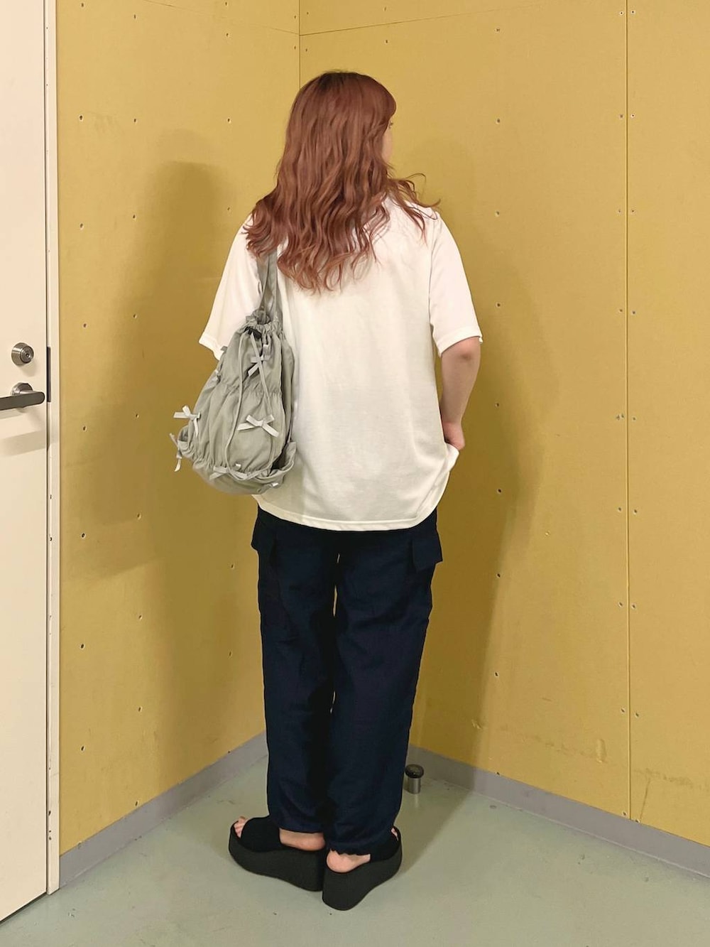 ブラック系のサンダル、ブルー系のカーゴパンツ、ホワイト系のTシャツ/カットソーを着用したレディースの夏コーディネートの3枚目の写真