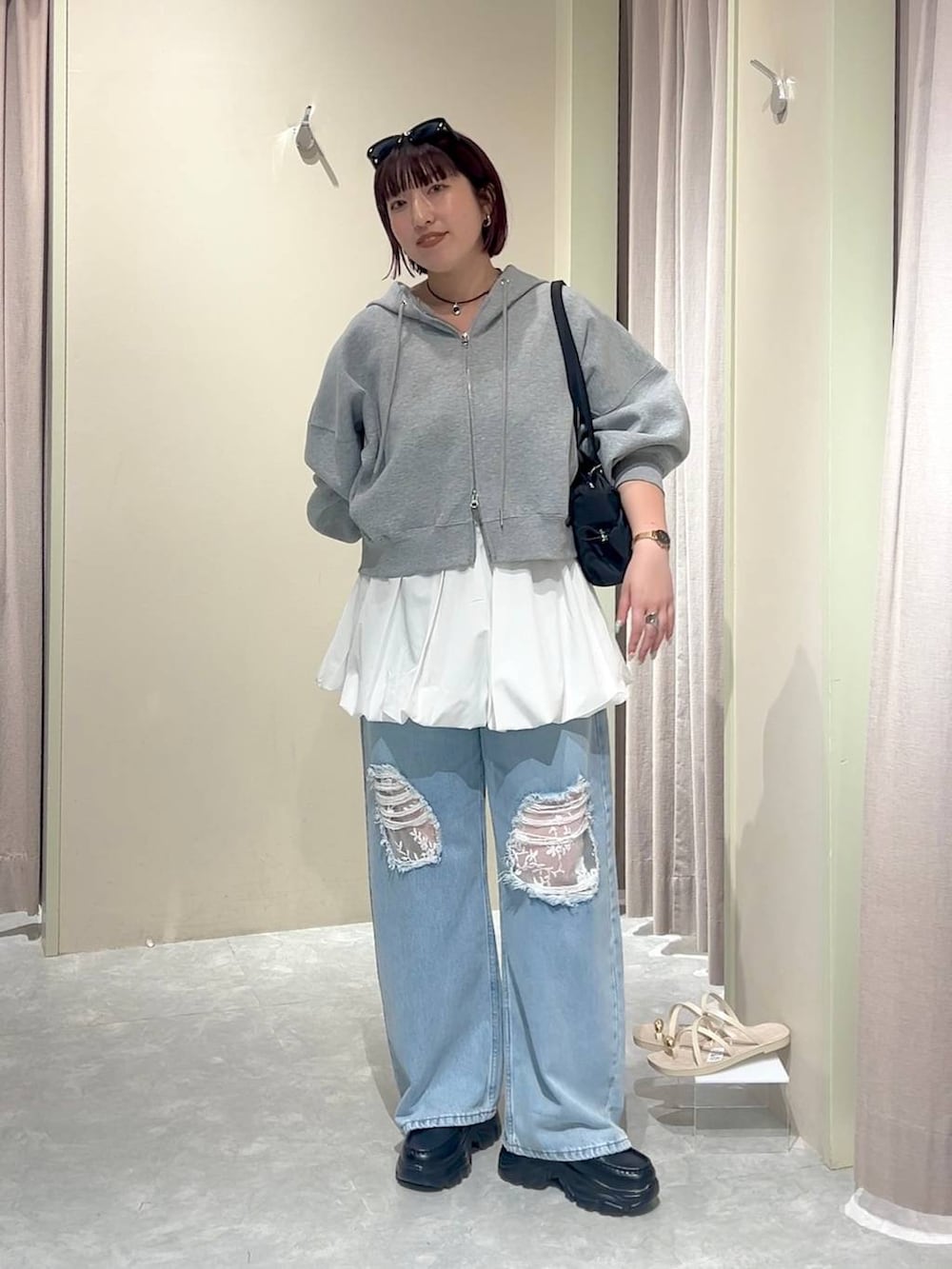 グレー系のパーカー、ブルー系のデニムパンツ、ブラック系のローファーを着用したレディースの秋コーディネートの8枚目の写真