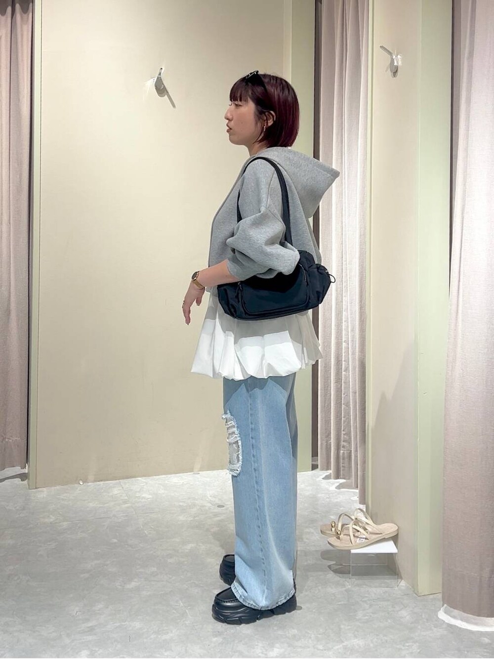 グレー系のパーカー、ブルー系のデニムパンツ、ブラック系のローファーを着用したレディースの秋コーディネートの4枚目の写真