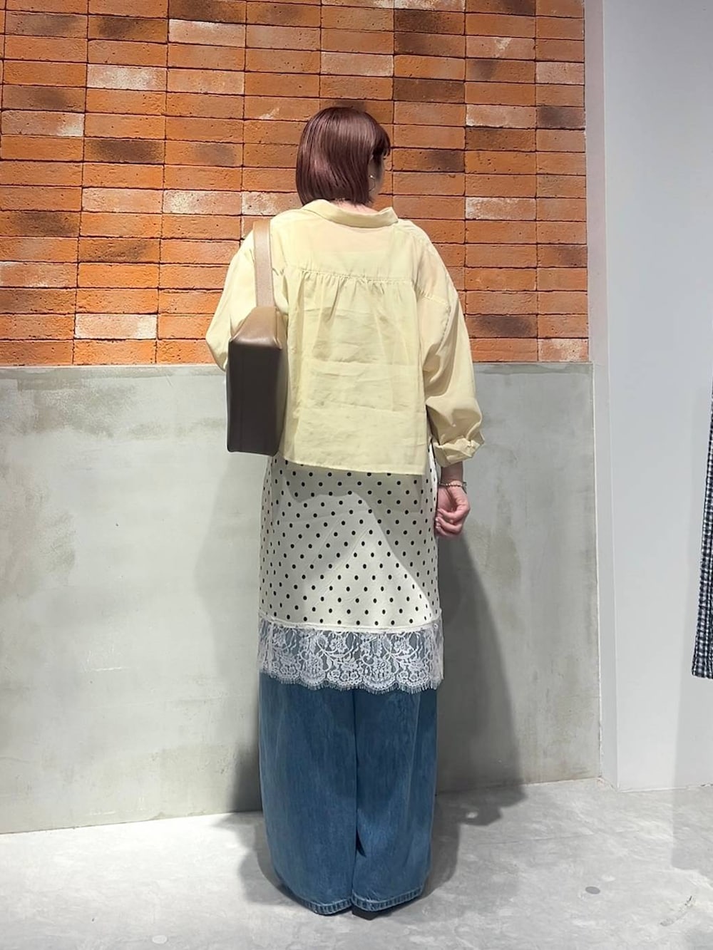 ゴールド系のタンクトップ、イエロー系のシャツ/ブラウス、ブルー系のデニムパンツを着用したレディースの夏コーディネートの3枚目の写真
