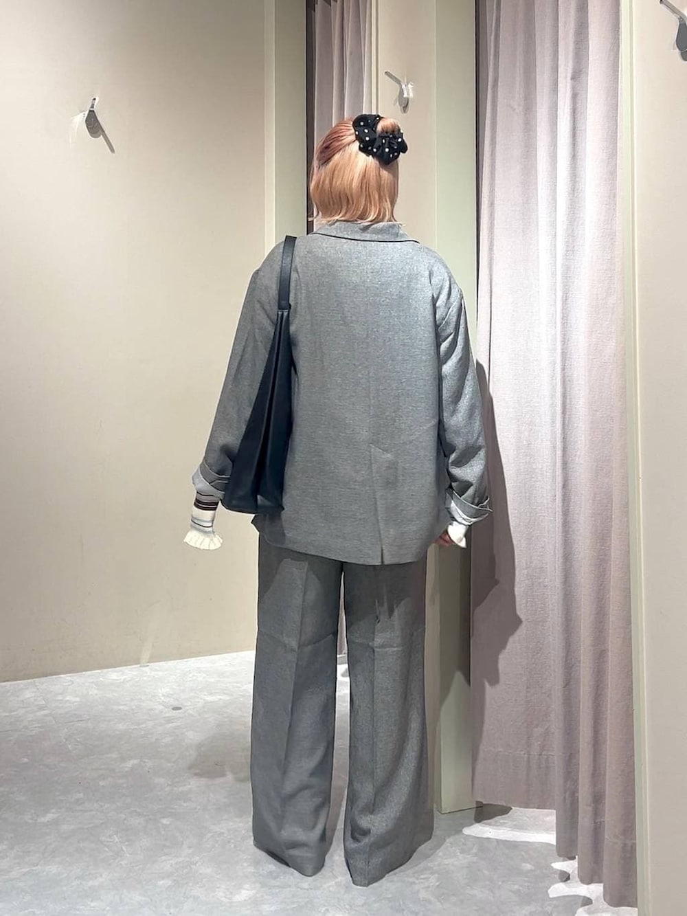 ブラック系のショルダーバッグ、グレー系のテーラードジャケット、グレー系のデニムパンツを着用したレディースの春コーディネートの3枚目の写真