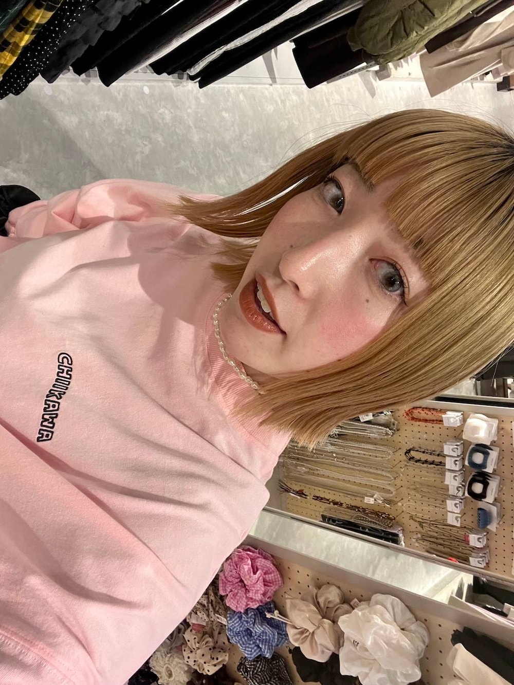 ブラック系のスカート、ピンク系のTシャツ/カットソー、ブラック系のシュシュを着用したレディースの冬コーディネートの2枚目の写真