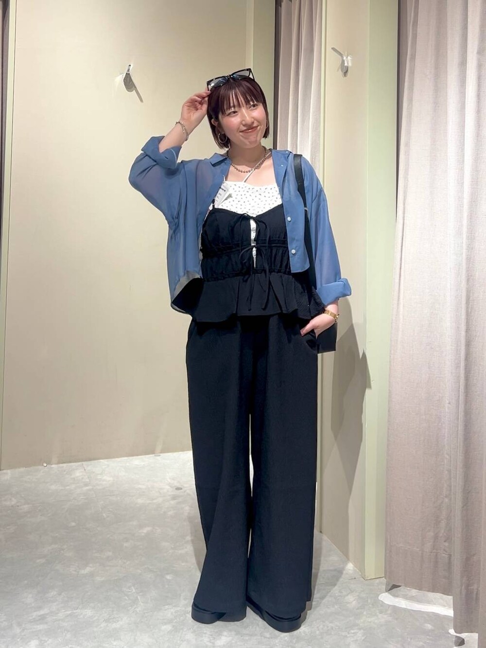 ブラック系のショルダーバッグ、ブルー系のシャツ/ブラウス、ブラック系のサンダルを着用したレディースの夏コーディネートの7枚目の写真