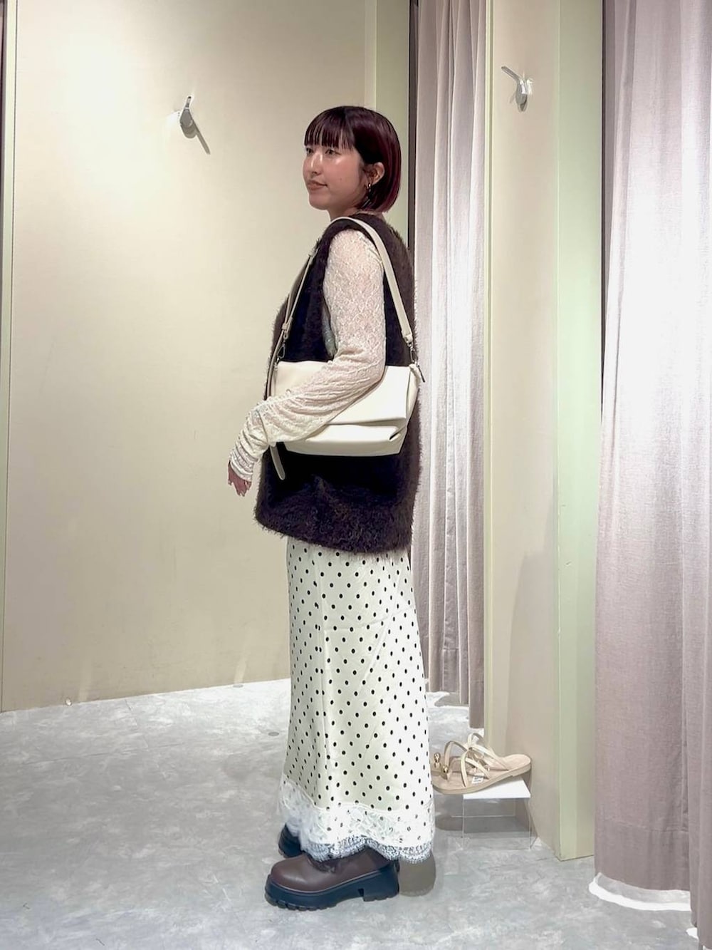 ブラウン系のブーツ、ホワイト系のショルダーバッグ、ホワイト系のTシャツ/カットソーを着用したレディースの秋コーディネートの2枚目の写真