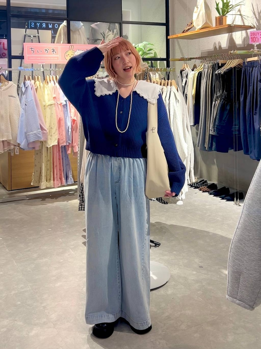 ブラック系のサンダル、ブルー系のデニムパンツ、ホワイト系のショルダーバッグを着用したレディースの冬コーディネートの6枚目の写真