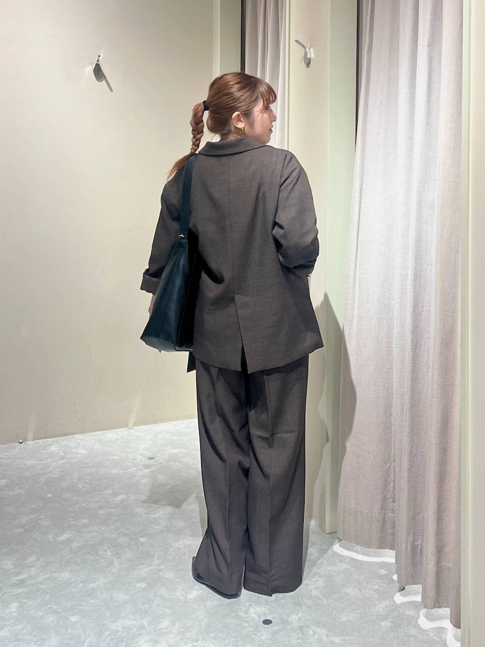 ブラウン系のテーラードジャケット、ブラウン系のその他パンツ、ホワイト系のキャミソールを着用したレディースの秋コーディネートの3枚目の写真