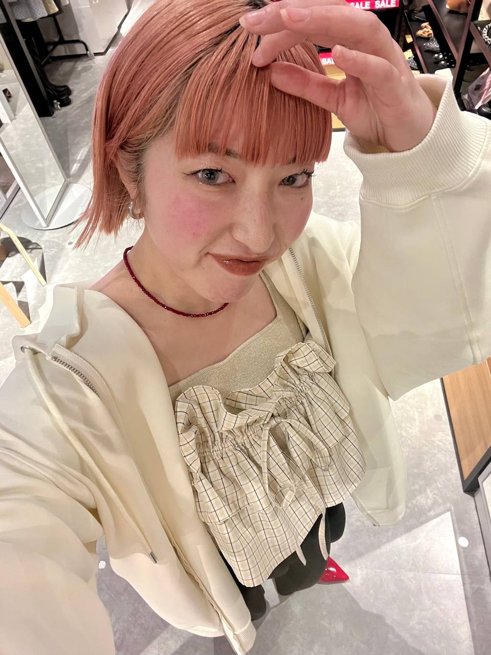 ブラック系のスウェットパンツ、ゴールド系のタンクトップ、ベージュ系のパーカーを着用したレディースの冬コーディネートの4枚目の写真