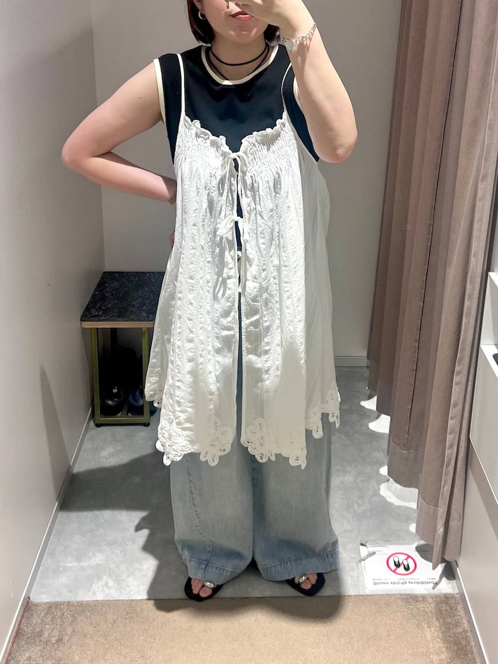 ブラック系のタンクトップ、ブルー系のデニムパンツ、ブラック系のサンダルを着用したレディースの夏コーディネートの5枚目の写真