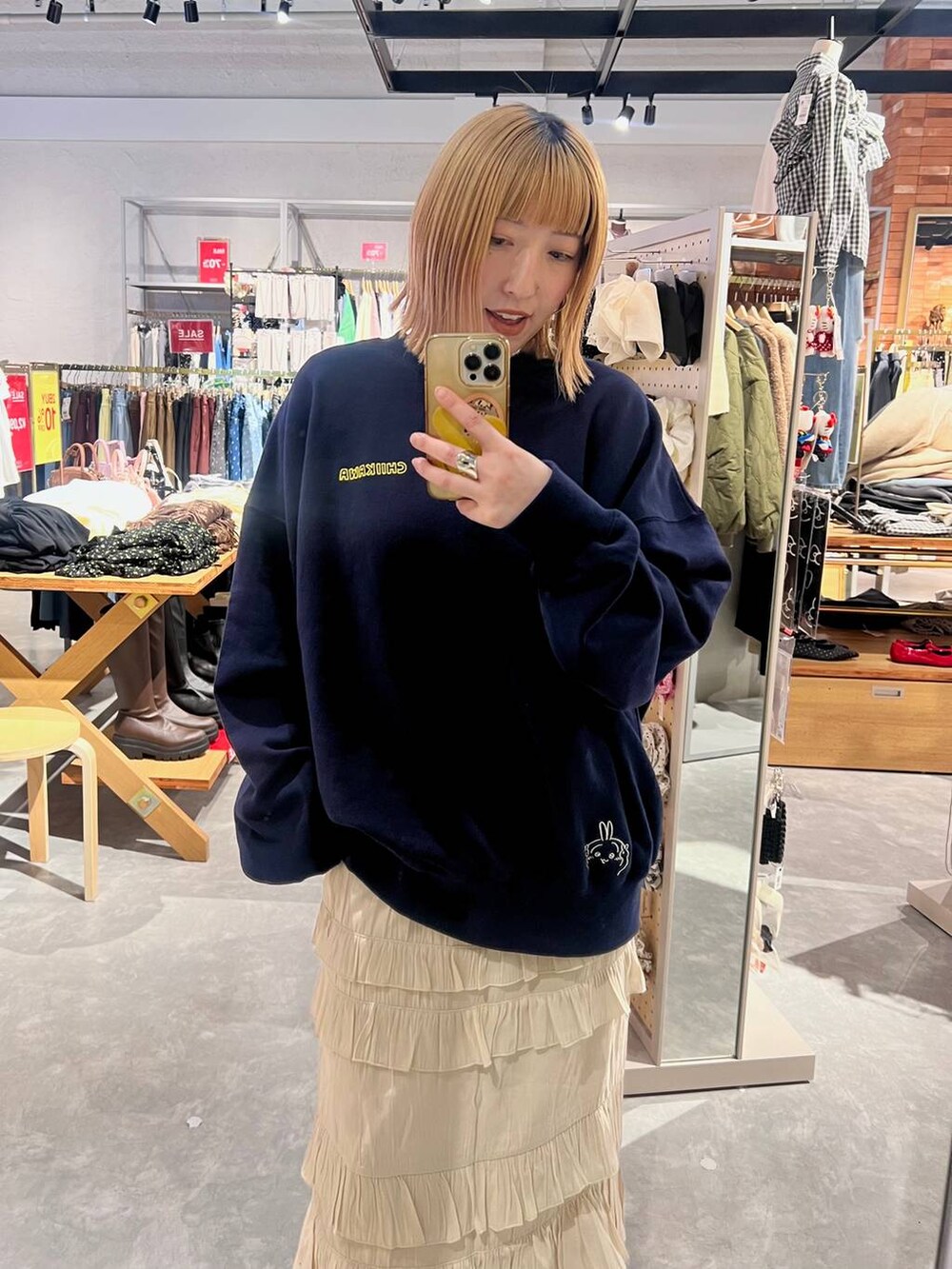 ブラック系のサンダル、ホワイト系のスカート、ブルー系のスウェットを着用したレディースの冬コーディネートの2枚目の写真