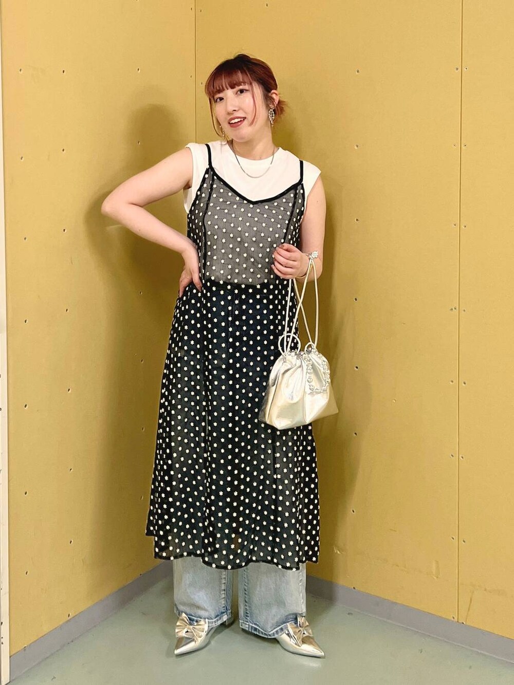 シルバー系のパンプス、シルバー系のショルダーバッグ、ブルー系のデニムパンツを着用したレディースの夏コーディネートの4枚目の写真