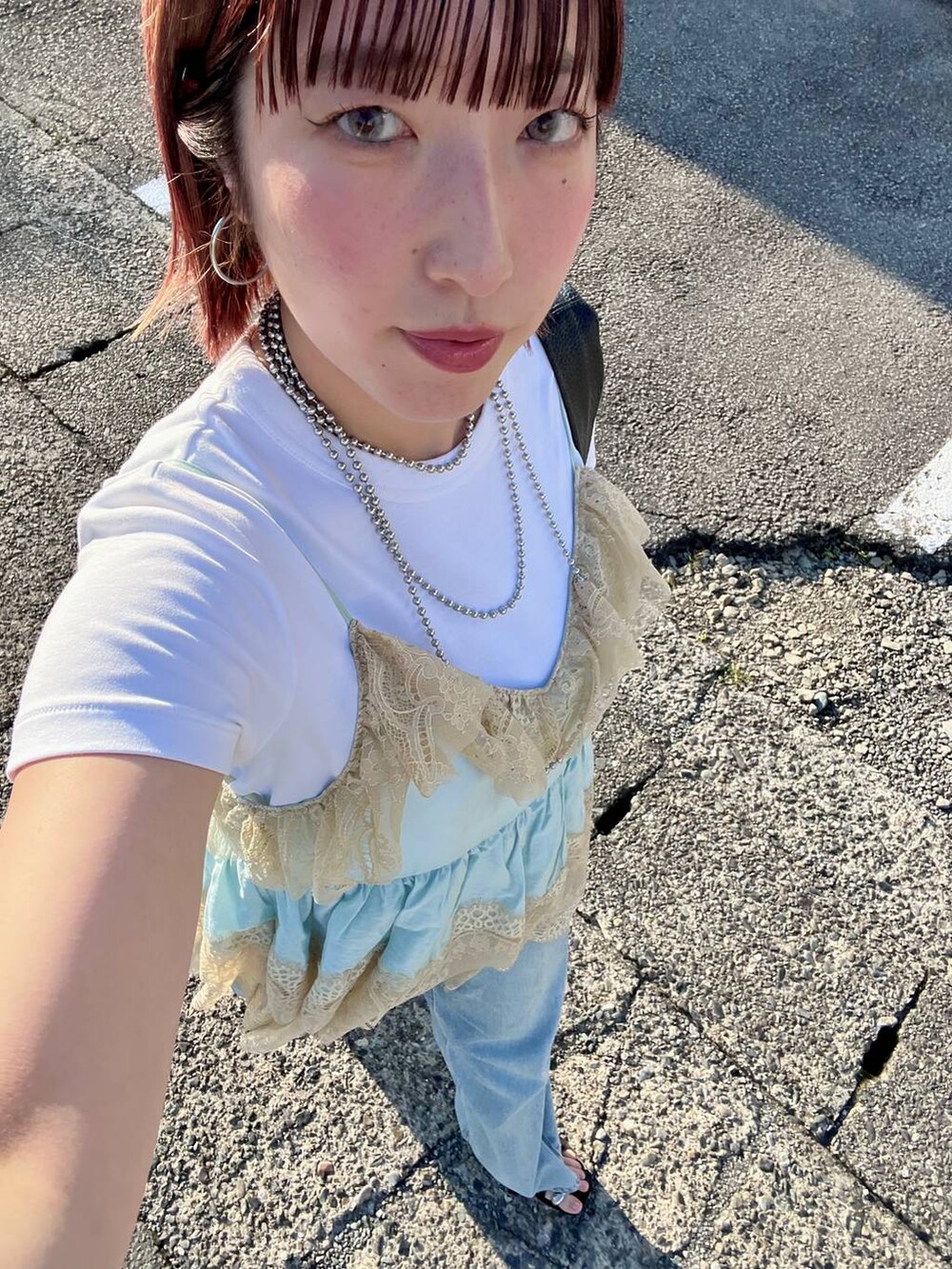 ブルー系のデニムパンツ、ブラック系のサンダル、ブルー系のその他トップスを着用したレディースの夏コーディネートの3枚目の写真