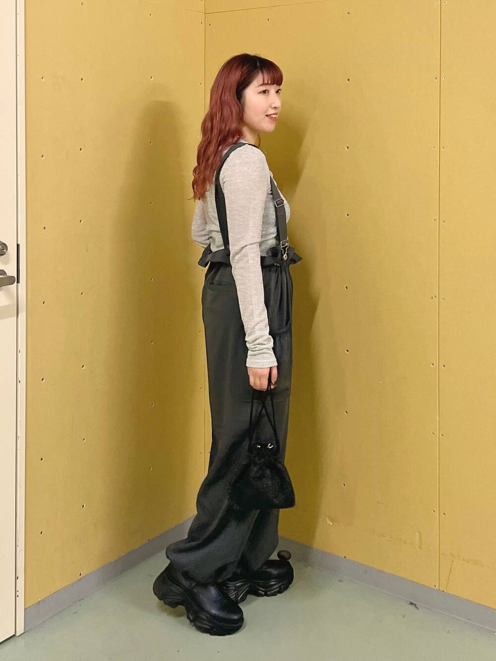 グレー系のワンピース、ブラック系のブーツ、グレー系のTシャツ/カットソーを着用したレディースの秋コーディネートの2枚目の写真