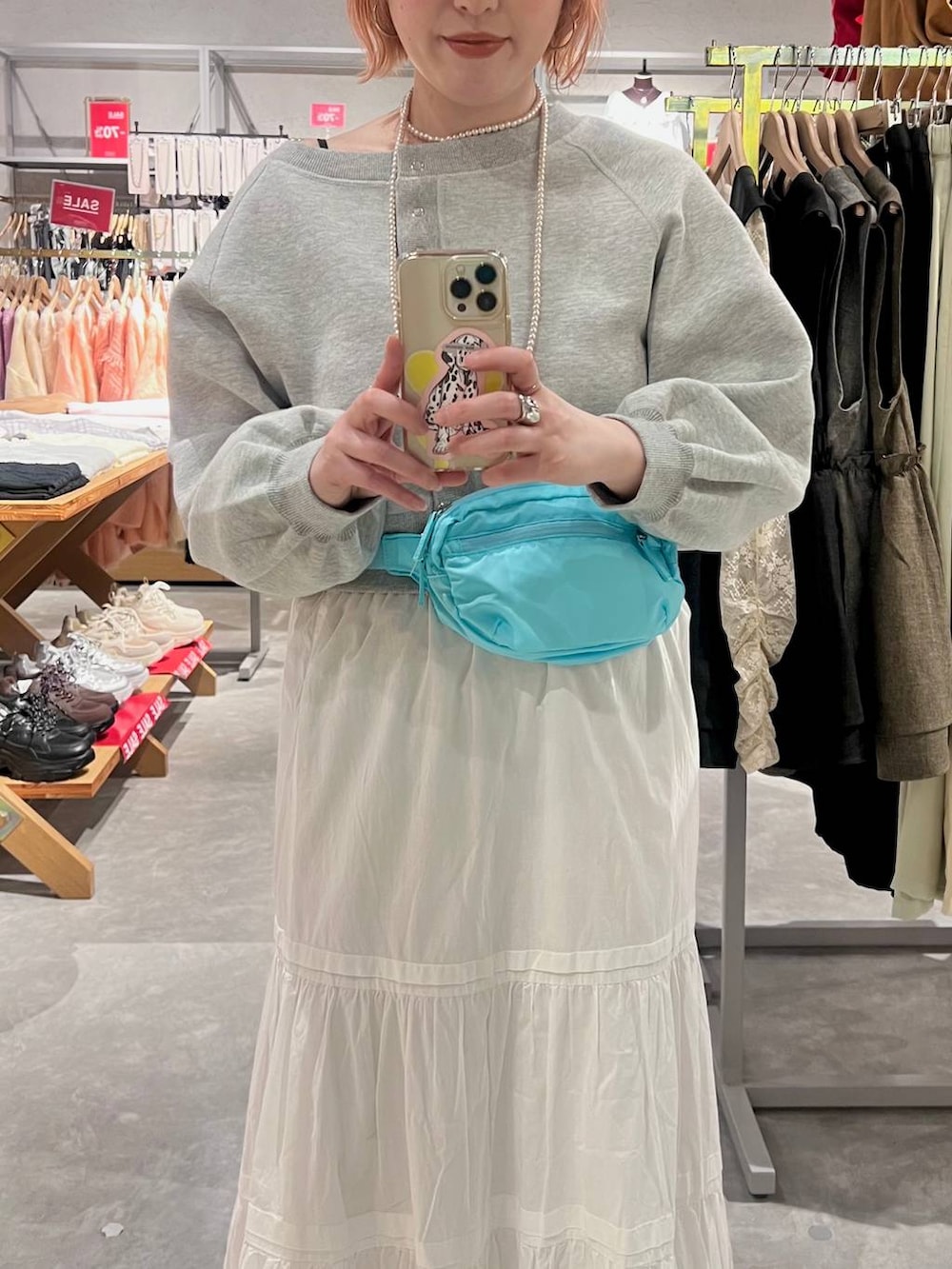 ブルー系のボディバッグ/ウエストポーチ、ブラック系のドレスシューズ、ホワイト系のスカートを着用したレディースの春コーディネートの2枚目の写真