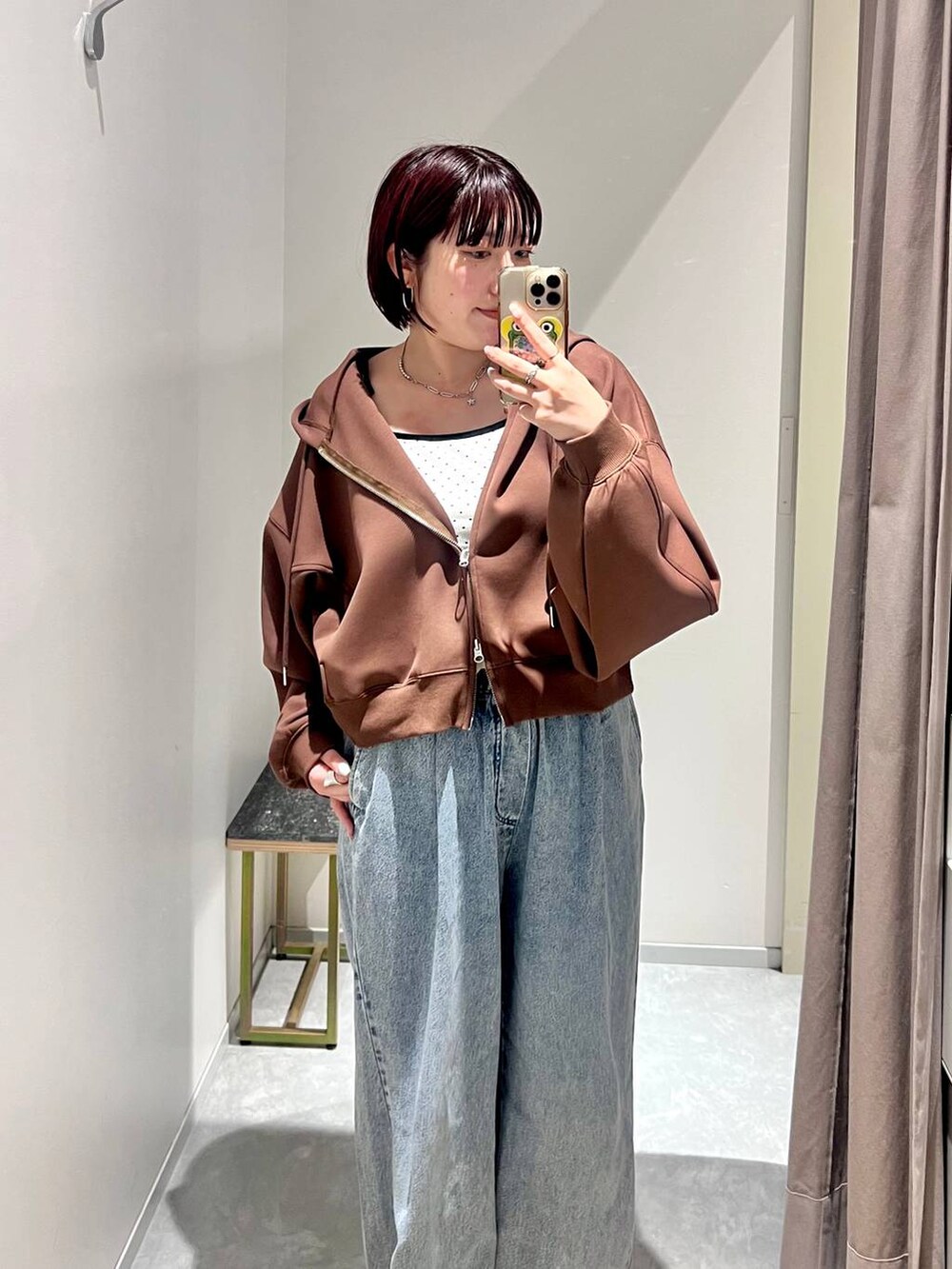 ホワイト系のキャミソール、ブルー系のデニムパンツ、ブラウン系のサンダルを着用したレディースの秋コーディネートの2枚目の写真