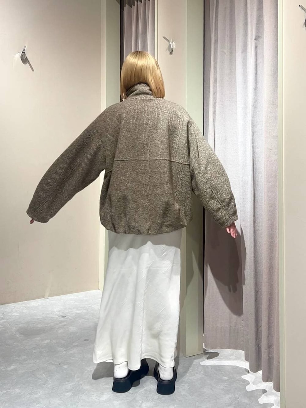 ホワイト系のスカート、ブラウン系のサンダル、ベージュ系のブルゾンを着用したレディースの冬コーディネートの3枚目の写真