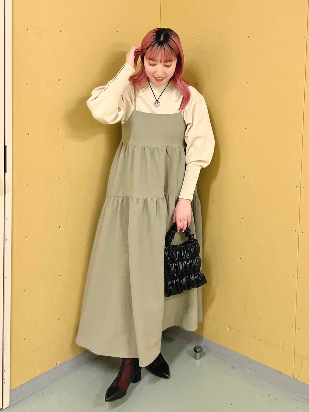 ブラック系のブーツ、ホワイト系のニット/セーター、ブラック系のショルダーバッグを着用したレディースの冬コーディネートの4枚目の写真