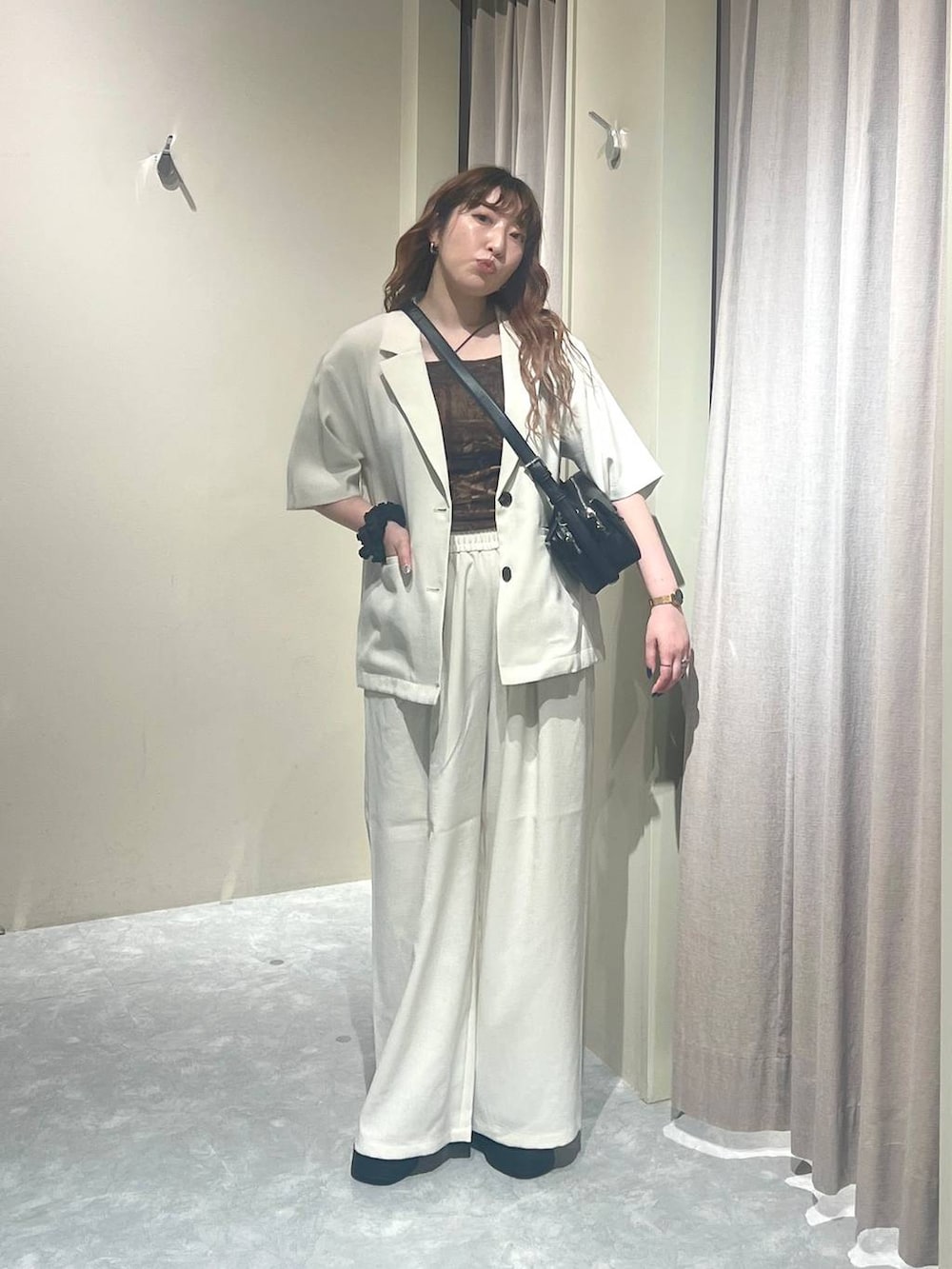 ホワイト系のテーラードジャケット、ホワイト系のその他パンツ、ブラック系のサンダルを着用したレディースの夏コーディネートの4枚目の写真