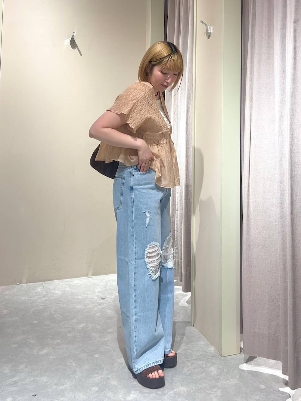 ブラウン系のショルダーバッグ、ブルー系のデニムパンツ、ブラウン系のサンダルを着用したレディースの春コーディネートの4枚目の写真